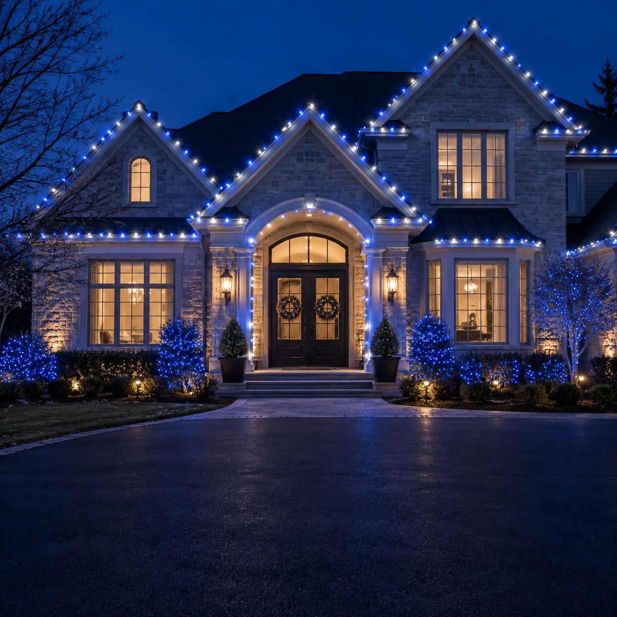 Blue and white lights outlining a home’s roofline, windows and entrance at night